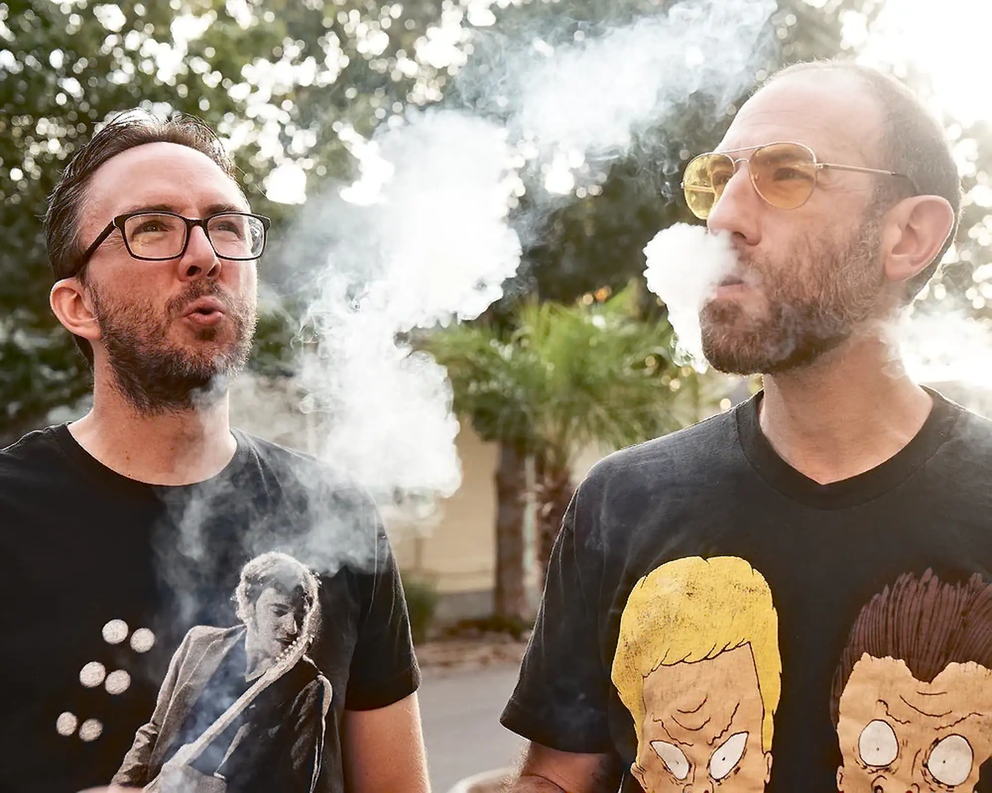Ari Shaffir Blowing Smoke with Joe | Joe List | Tuesdays with Stories Comedian Ari Shaffir exhaling smoke while smoking with comedian Joe List of Tuesdays with Stories lighting a cigarette in a suit at comedian Mark Normand's wedding to Mae Planert in New Orleans. Find more about Joe at www.tuesdayspod.com/joe-list